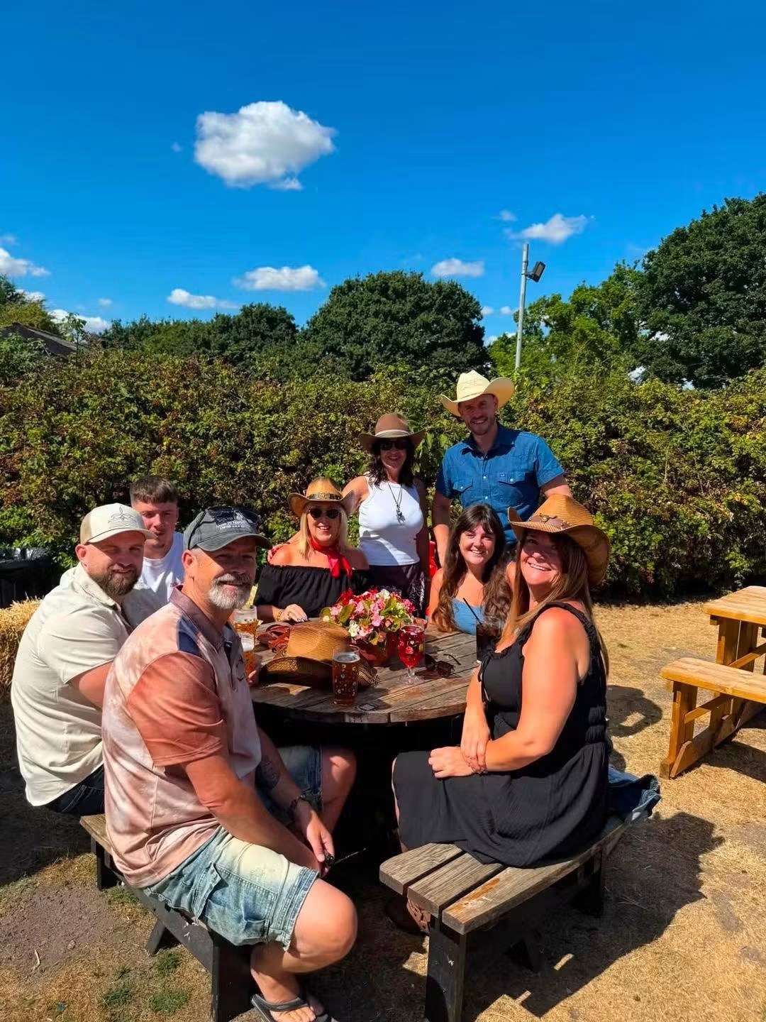 Group of line dancers in cowboy hats relaxing around a table after a class